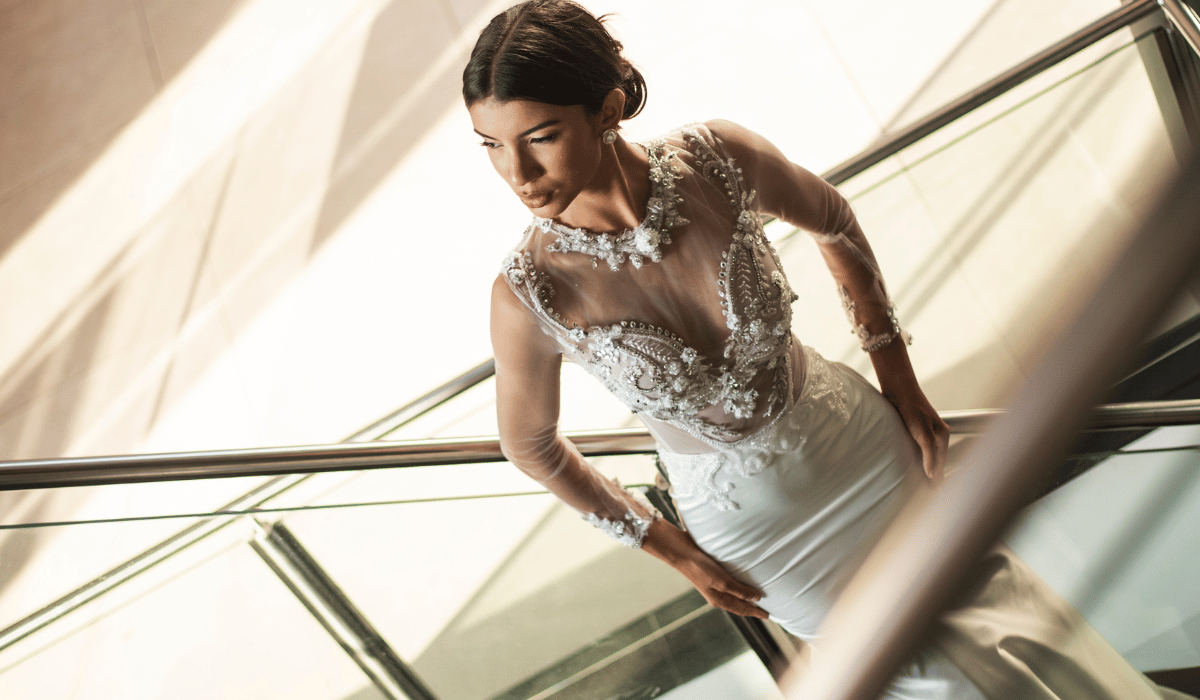 Noiva elegante com vestido justo de pedrarias em escada